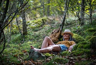 femme allongée dans l'herbe en forêt